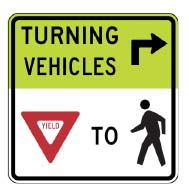 Figure 9, MUTCD Sign R10-15: Turning Vehicles Yield to Pedestrians
Figure 8 is a picture of a street sign that indicates, using words arrows, and icons, that turning vehicles need to yield to pedestrians.